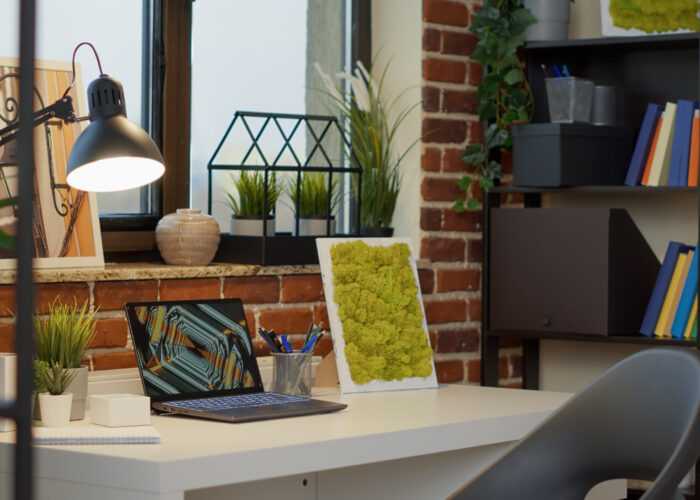 No people at empty desk with laptop computer in apartment, to use modern digital technology for entertainment. Nobody at home office with interior decorations, creative indoors style.